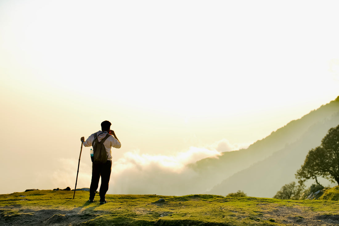hiker sipping cold water on a mountain trail while taking in the vista