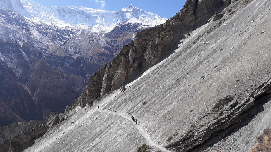 hikers walking across a high mountain trail with drinking water for altitude hydration