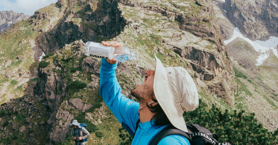 group of hikers walking on a mountain trail carrying water bottles