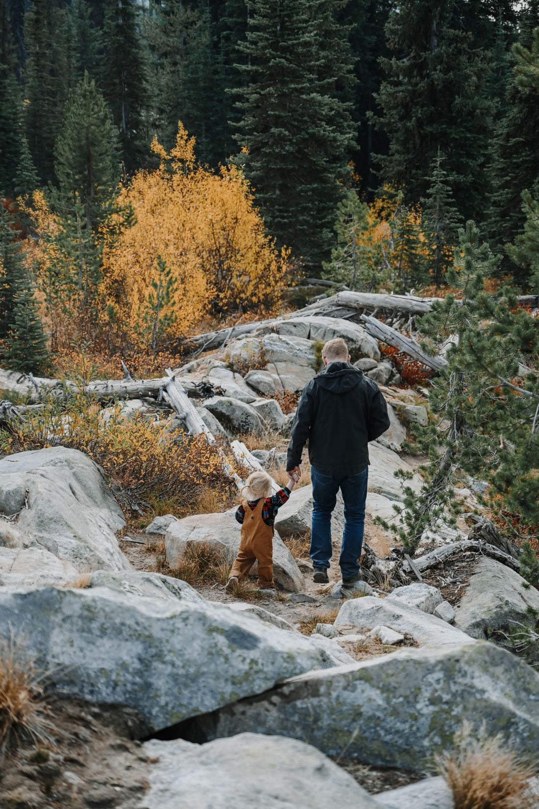 Father and child hiking through autumn forest with water bottles, keeping kids hydrated on a family hike